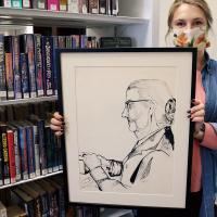 Brigette Scheffler holds up the pen and ink drawing of Mrs. G.F. Gateka