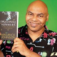 Maurice Johnson holds up a copy of his book Dragonfly Summers
