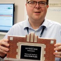 Brian Rukes holds up one of the replicas of the new walls