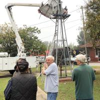 Volunteers worked Friday to take down the historic windmill