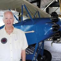 Tony Caldwell in front of one of the vintage aircraft on display at the Caldwell Collection