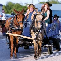 Craig McVay halts his mule team and the wagon pulling several couples