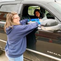 Jorski hands homework to Maples outside Sacred Heart Catholic School