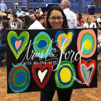 Vania Novotny holds up one of the works of art that were auctioned off