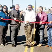 Reggie Wassana and Marc Hader cut the ribbon as others join in
