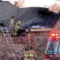 El Reno firefighters use a pick to break away the roof on this home