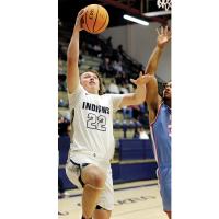 Jacob Robertson uses his arm to screen off an Eagles defender while shooting a layup. 