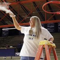 Jennifer Douglas twirls one of the nets at Jenks Simmons Field House that was cut down