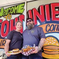 Cade and Laci Brickey hold up their version of a fried onion burger