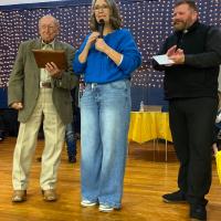 Ken Reding holds the plaque he was presented for serving three decades as auctioneer at the Taste of Sacred Heart