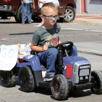 Malachi Still rides a remote-controlled tractor in the parade