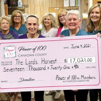 Members of The Power of 100 present an oversized check to Nikki Pruitt