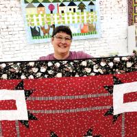 MaCrae Putnam shows off some of the quilts to be displayed