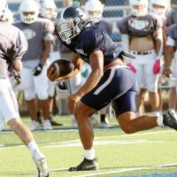 Malachi Nicholson looks toward an Elk City tackler while breaking into open territory