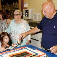 Craig McVay serves cake to his granddaughters Ellie and Lena
