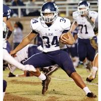 El Reno High School senior Mikey Devereaux carries the ball in the win over Altus.