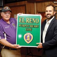 Mitch Reed presents Matt Sandidge with one of the Purple Heart signs