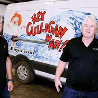 Brian and Greg Mollman stand next to one of the delivery vehicles their business uses to deliver water