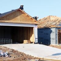 Construction workers roofing one of the new homes under construction