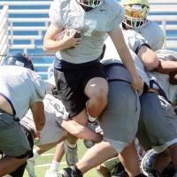 Grant First tries to leap past an arm tackle and through a small hole in the line