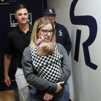 Chase Johnson walks toward a team meeting with wife, Jade and daughter, Elsie