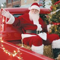Santa Claus and a little helper wave to the crowd