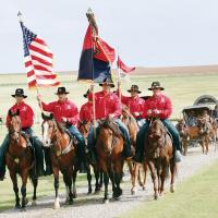 The Commanding General’s Mounted Color Guard from Fort Riley leads the wagon trail