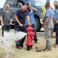 Jason Duff watches a spray of water shoot out of a hydrant along Jensen Road