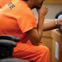 Inmates are seen within a jury box during court proceedings
