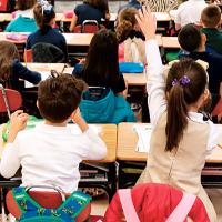 A second-grader raises her hand in class at Nichols Hills Elementary School