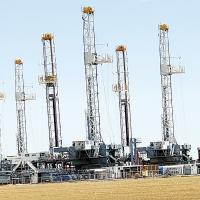 Oil derricks sit in a field northeast of Calumet