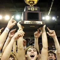 Hunter Mueggenborg holds up the Class A gold ball after the Warriors completed a perfect season to retain the state title