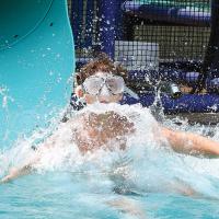 Gage Baeriswyl wears a pair of goggles as he splashes into the water