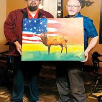 Alan Fletcher, left, presents the painting to Brien Detamore