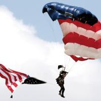 A member of the All Veteran Group parachute team floats to the ground