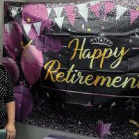 Becky Wahler stands next to her retirement party banner