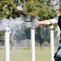 Robert Buchanan breaks a balloon with a fiery blast from his pistol