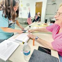 Becky Lockler shows her identification to a polling site worker