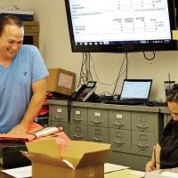 Allen Arnold and Jenny Miller work on data received from precincts
