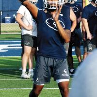 Elijah Fisher throws a pass downfield 