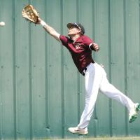 Dustin Whitmire leaps into the air as he tries to snag a fly ball