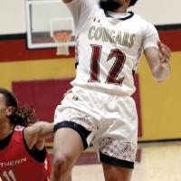 Deazhon Perkins (12) throws up a one-handed running jumper
