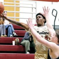 Amaree Garmon reaches around a defender from South Central Prep on a driving layup attempt