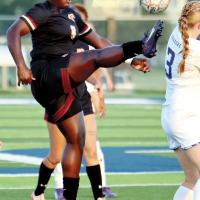 Ashinti Lewis jumps into the air to redirect a goalie kick back toward a teammate
