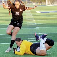 Izzy Bolton steps over a goalie after having a shot stopped