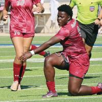 Ashanti Lewis slides along the turf to make a low shot