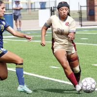 Riley Robertson dribbles the ball around a defender