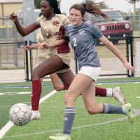 Ariana Whitfield leaps past a player to clear the ball