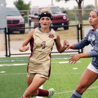 McKenize Simon runs under a bouncing ball