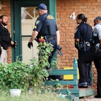 El Reno police, with guns drawn, prepare to execute a search warrant